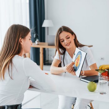 woman-showing-illustration-to-the-female-customer-resize-pttloswhei6f6se6snhpldvxp5cflv0znyoar1z86k